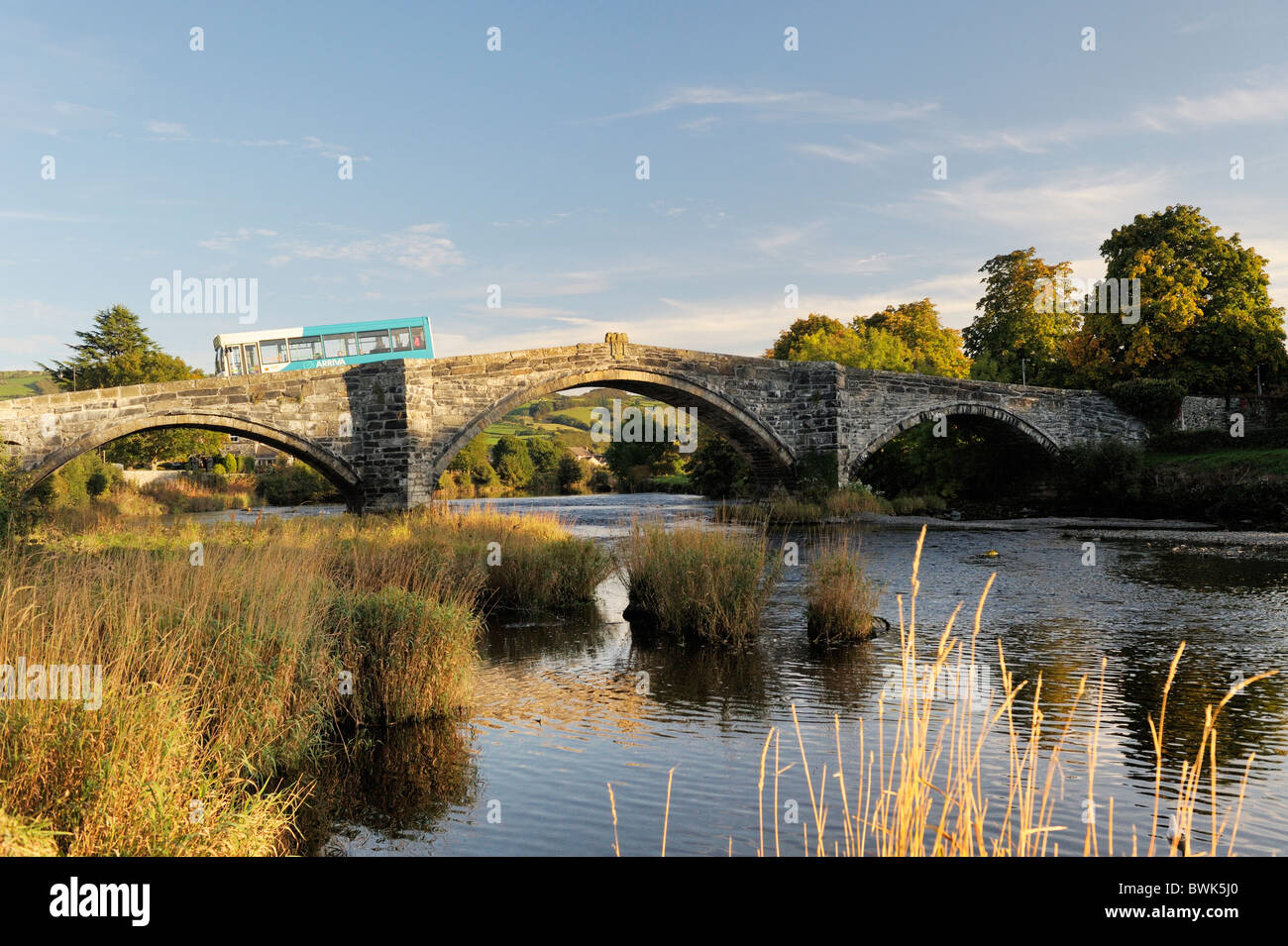 Bus arriva traverse la rivière Conwy sur le Pont Fawr bridge dans la vieille ville de Conwy dans la vallée de Conwy, Gwynedd, Pays de Galles, Royaume-Uni Banque D'Images