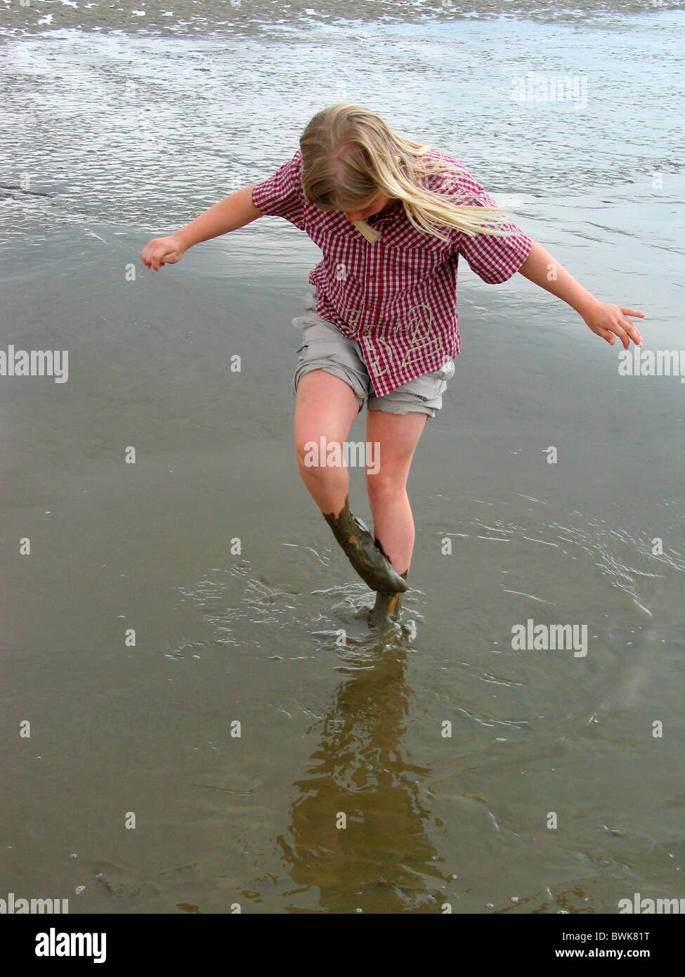Petite fille à l'extérieur de slime de boue à watt des boues les marées sur la côte de la mer d'errance marche Saint Peter Ording Ge Banque D'Images