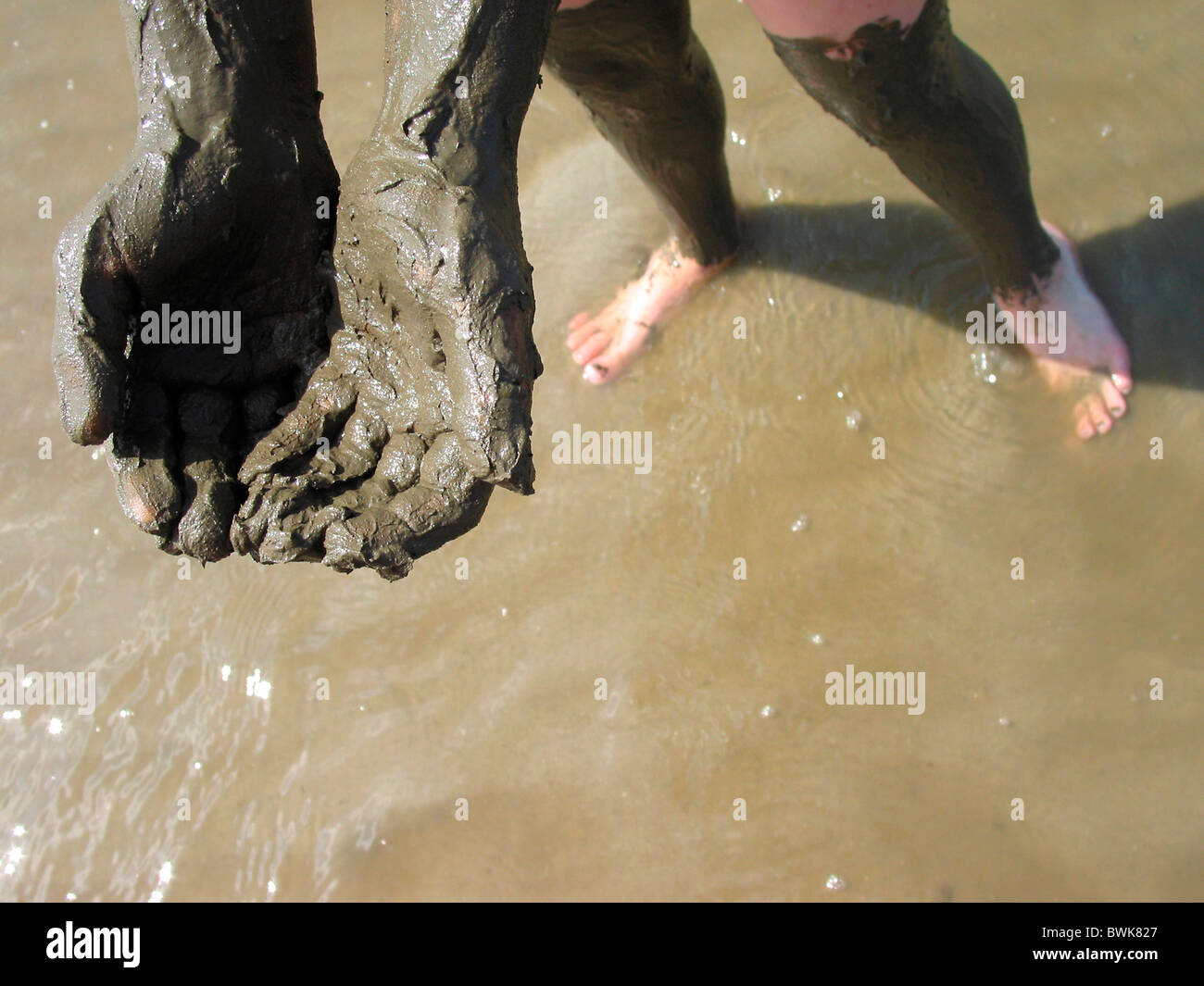 Petite fille à l'extérieur de salir les mains de boue boues marées slime à watt Sea coast walking wandering St. Pe Banque D'Images