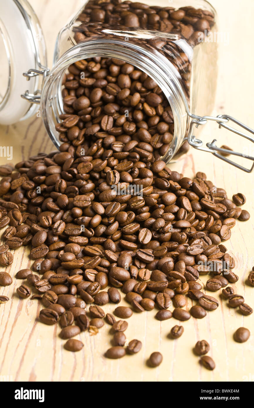 Les grains de café versé un pot de Banque D'Images