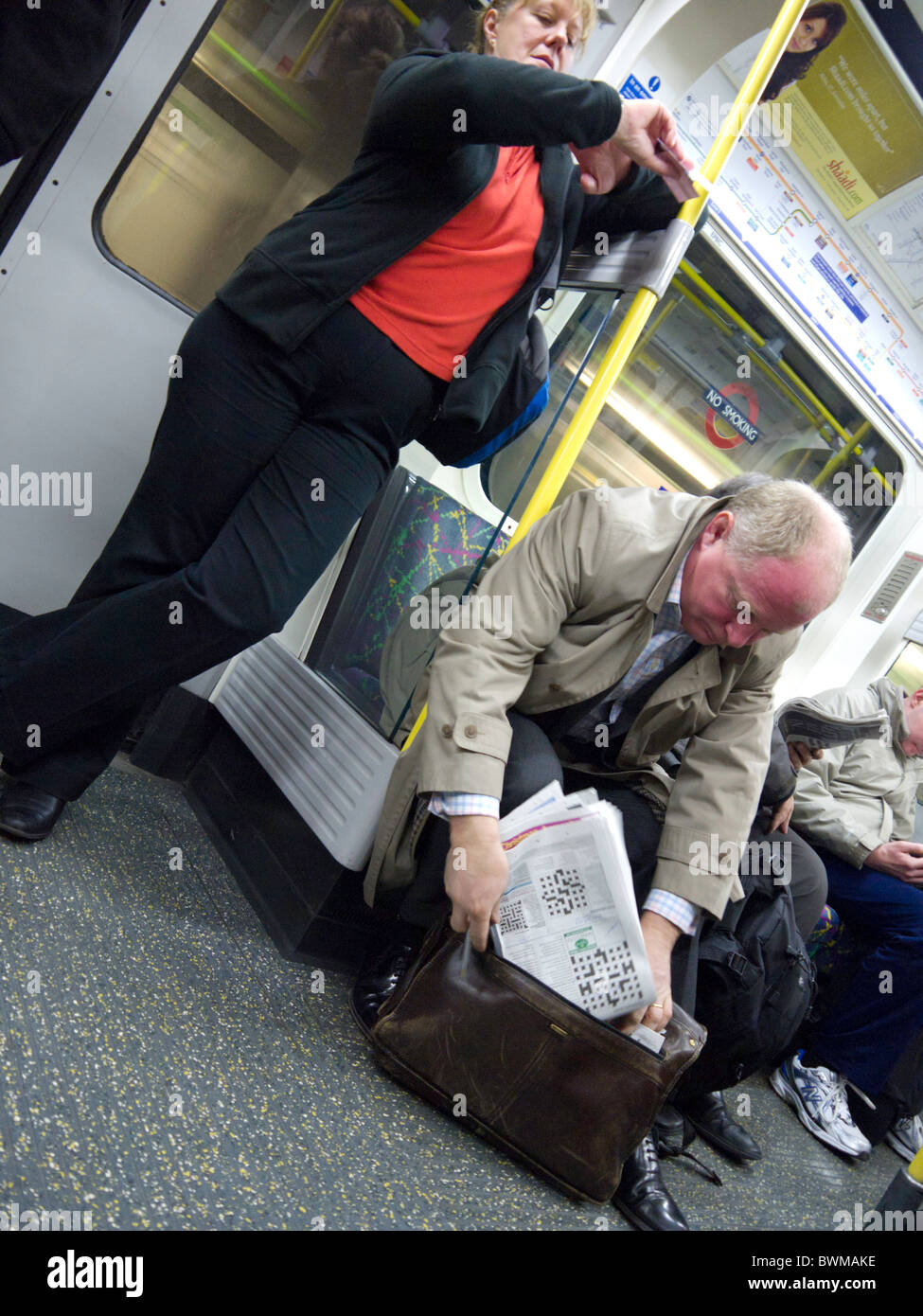 Contrôle de la femme sur sa montre sur le métro Circle line train de tube Banque D'Images