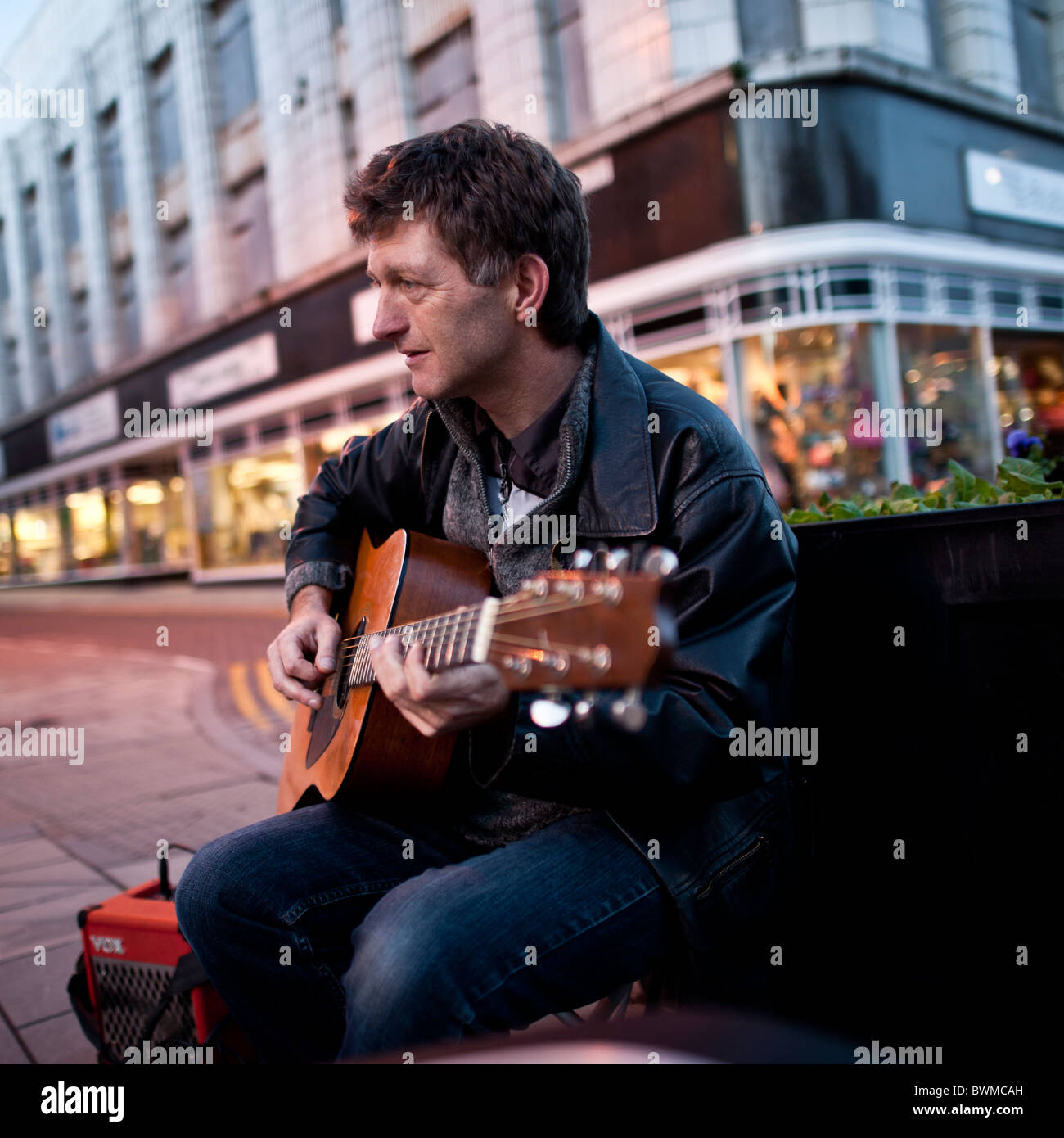 Un homme qui joue de la guitare de la rue dans les rues d'Aberystwyth, Pays de Galles UK Banque D'Images