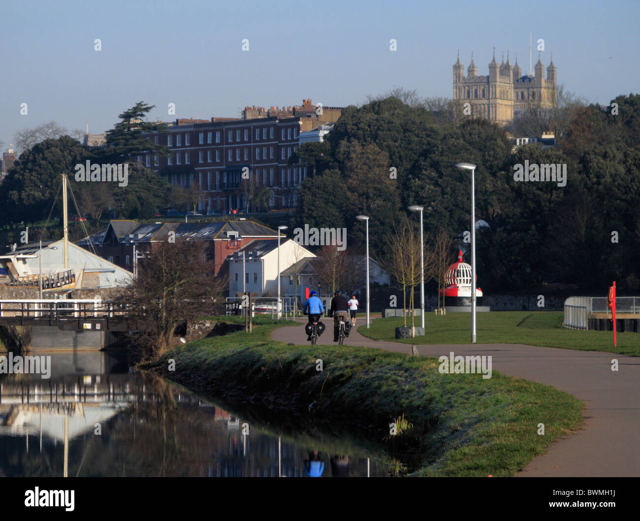 Canal d'Exeter avec vue sur cathédrale en arrière-plan Exe valley randonnée à vélo avec les randonneurs cyclistes Devon UK Banque D'Images