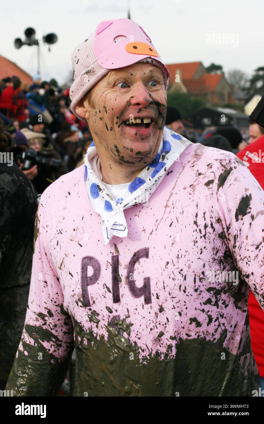 Homme dreesed comme un cochon rose couvert de boue après avoir terminé la course de boue Maldon Banque D'Images