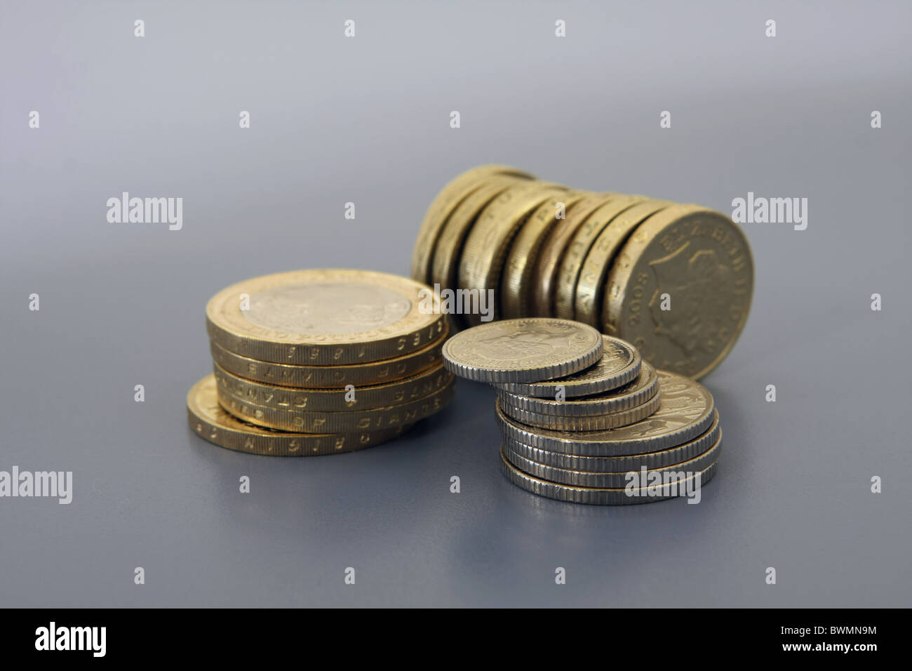 Une pile de £2 pièces à côté d'une pile de 5p de pièces sur toutes les pièces de 10p en face d'une rangée de £1 pièces Banque D'Images