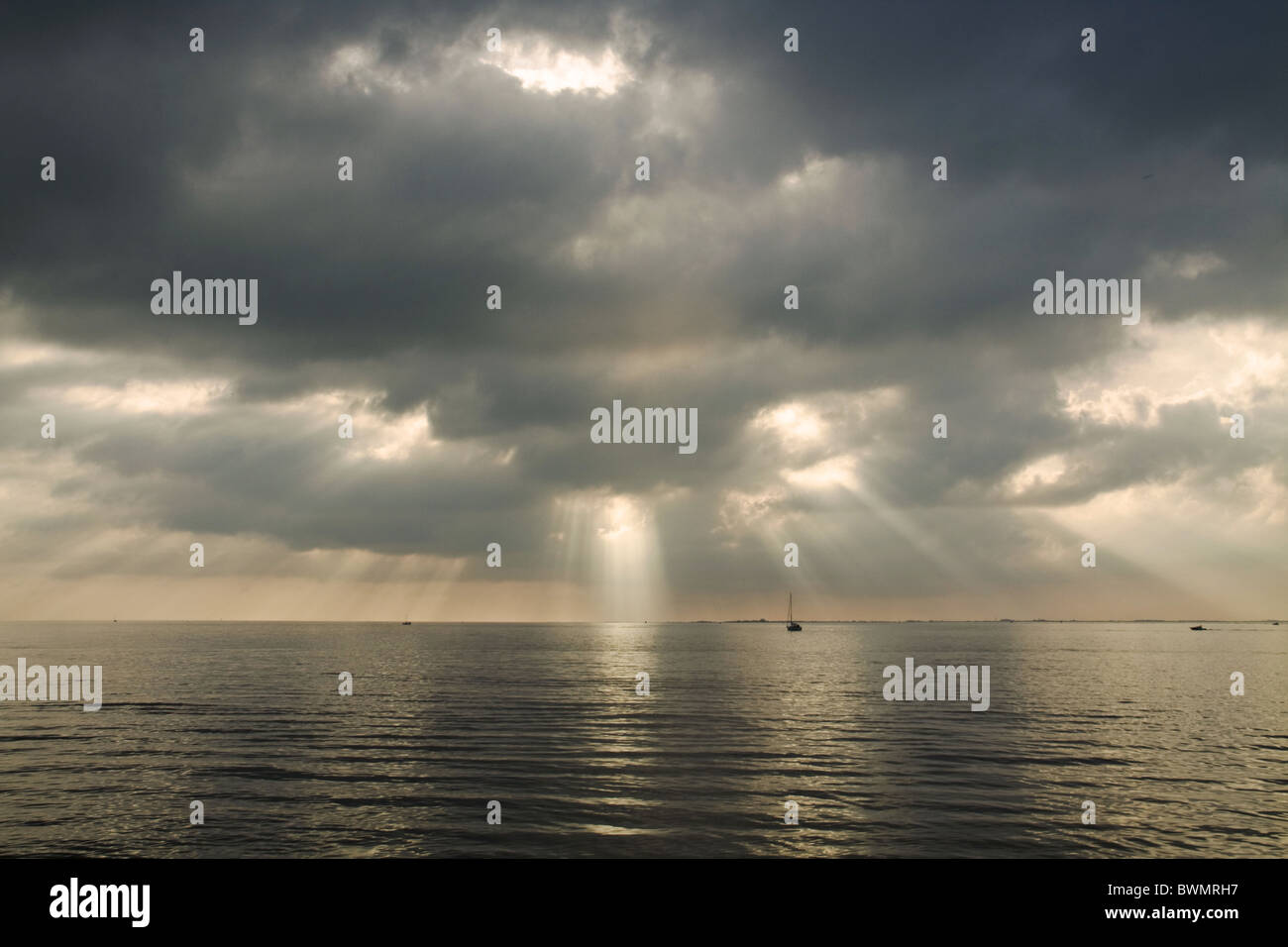 Rayons de soleil perçant les nuages et reflétant la lumière avec de l'argent sur la mer en un jour froid de novembre Banque D'Images
