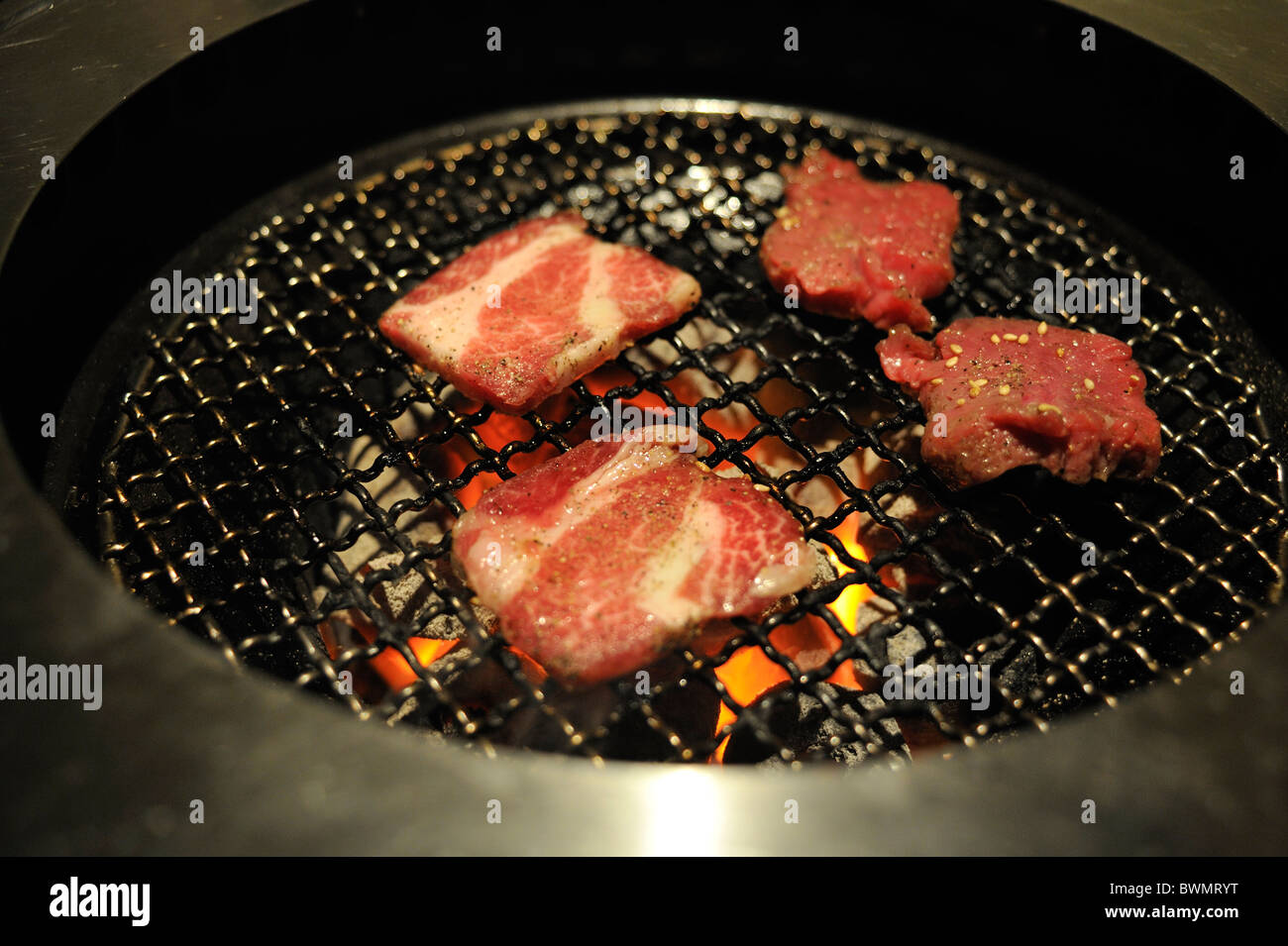 Morceaux de boeuf sur un gril de table dans un restaurant barbecue coréen. Tokyo, Japon. Banque D'Images