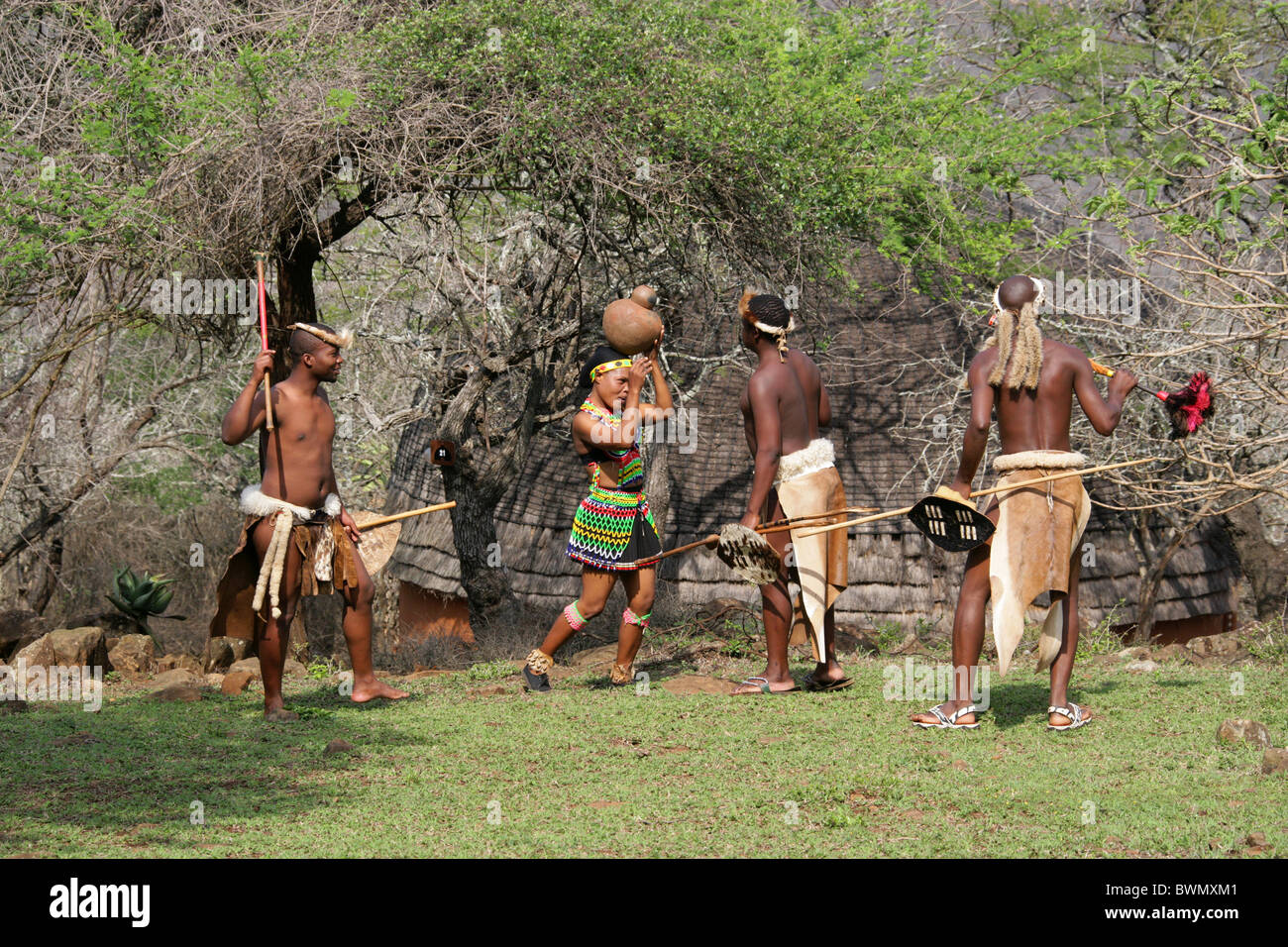 Les jeunes guerriers zoulous flirter avec une jeune fille, Zoulou zoulou de Shakaland, Village Vallée Nkwalini, Kwazulu Natal, Afrique du Sud. Banque D'Images