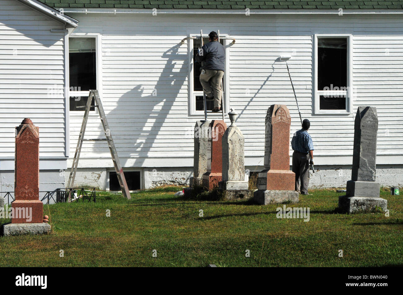 Les réparations des accidents et la peinture d'une église. Au premier plan sont les pierres tombales du cimetière adjacent. Banque D'Images