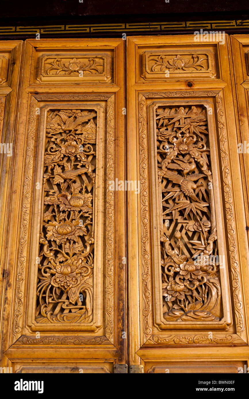 Portes en bois sculpté sur un bâtiment dans la vieille ville de Dayan, Lijiang, Yunnan Province, China Banque D'Images