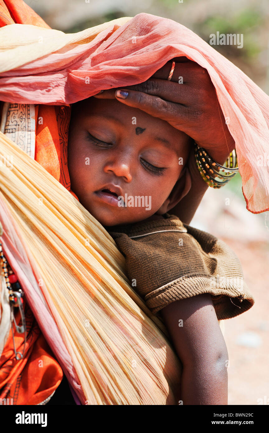 Les mères indiennes rurales bébé en sling protégé contre le soleil. L'Andhra Pradesh, Inde Banque D'Images