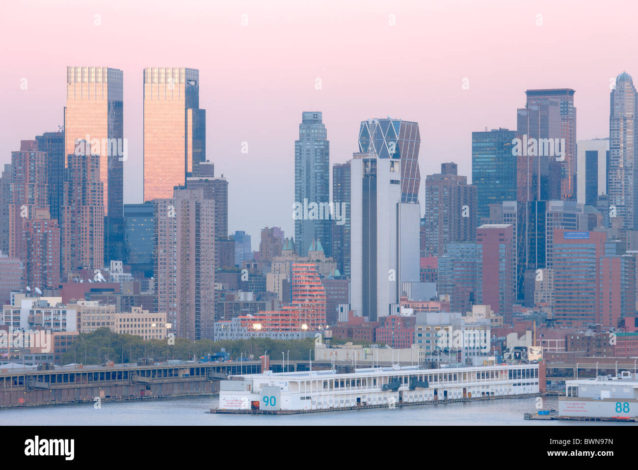 L'horizon de Manhattan au crépuscule derrière les piliers de la Manhattan Cruise Terminal sur la Rivière Hudson Banque D'Images