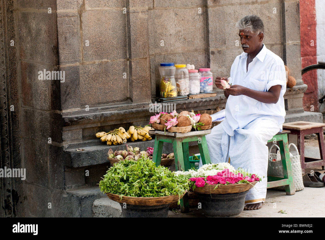 Marchande de fleurs assis en face de l'Ulagalanda Perumal temple à kancheepuram;Kanchipuram, Tamil Nadu Inde.matin. Banque D'Images