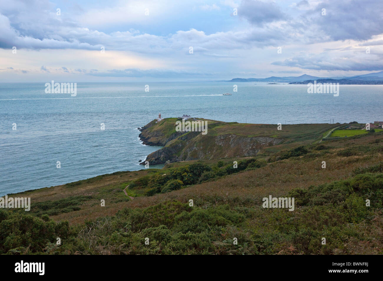 Phare Baily à Howth Head avec en arrière-plan de la baie de Dublin, Dublin, Irlande. UK à Dublin ferry (catamaran) la mer en arrière-plan. Banque D'Images