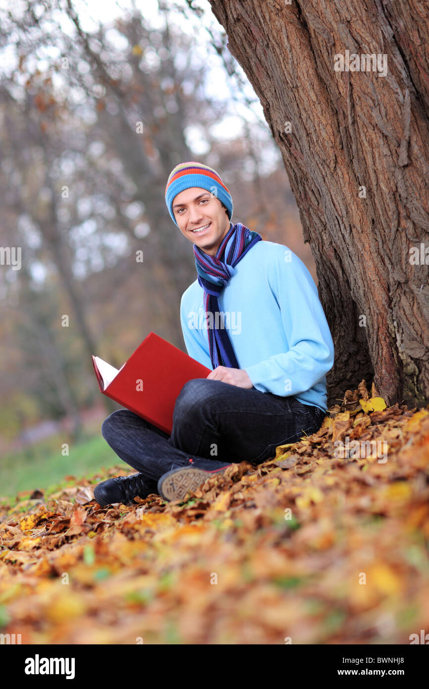 Jeune homme avec bonnet et écharpe en lisant un livre Photo Stock - Alamy