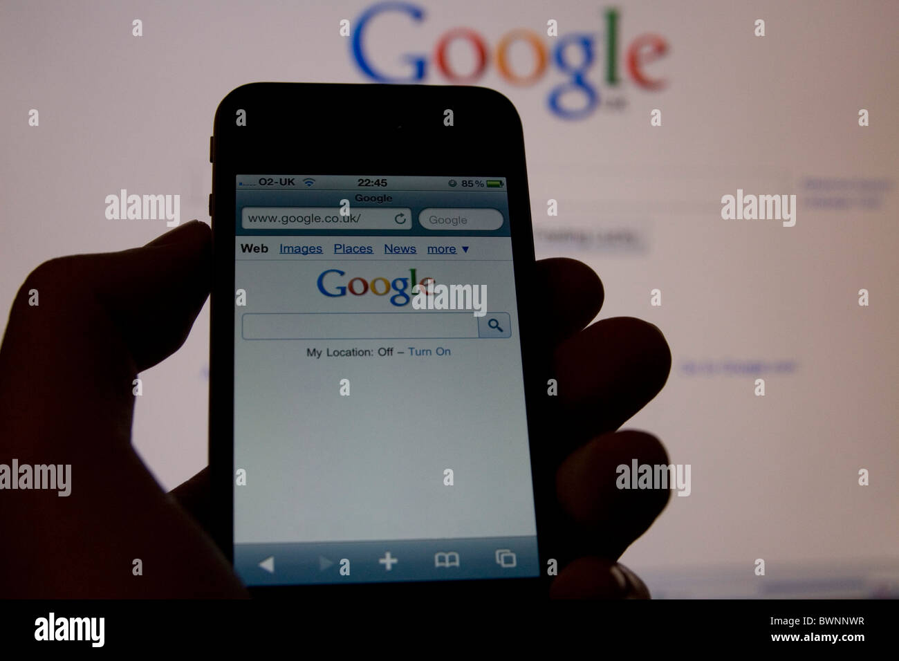 Un Apple iPhone 4 téléphone intelligent montrant Google mobile avec le site complet sur l'affichage à l'arrière-plan Banque D'Images