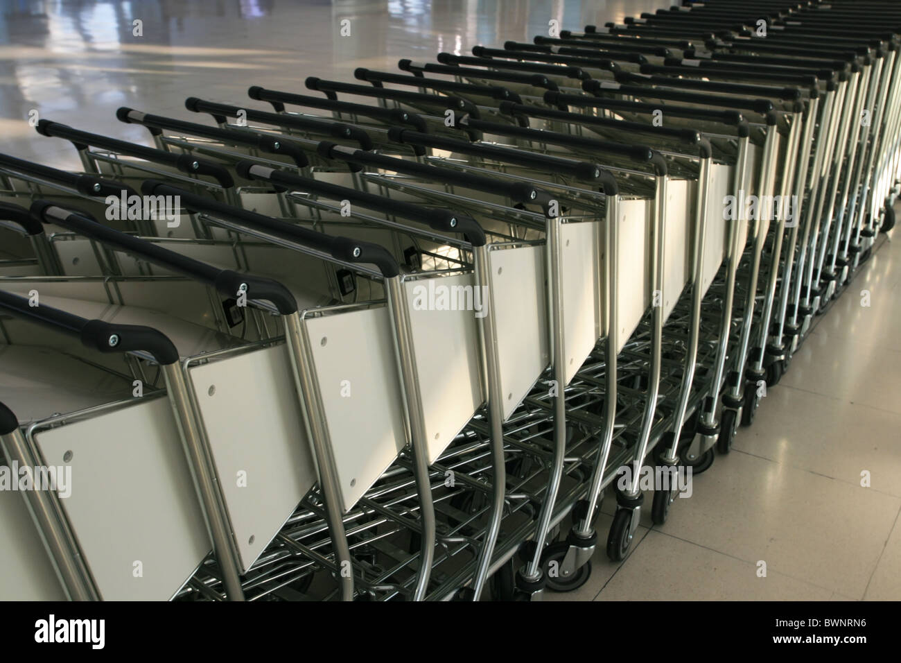 Rangées de chariots à bagages de l'aéroport pour les passagers prêts à les utiliser Banque D'Images