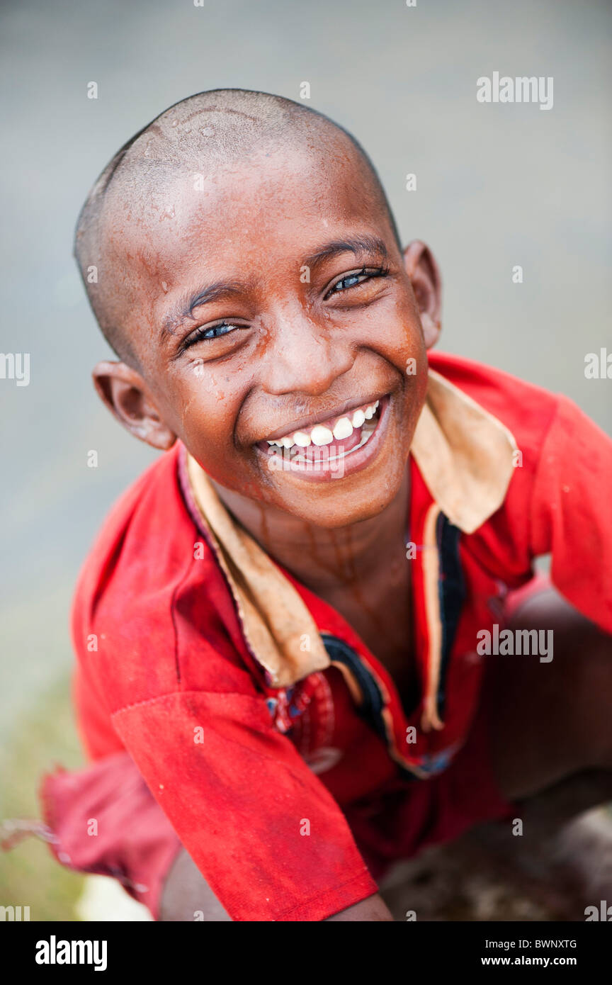 Smiling Indian street boy lave lui-même dans une rivière dans la campagne indienne. L'Andhra Pradesh, Inde Banque D'Images