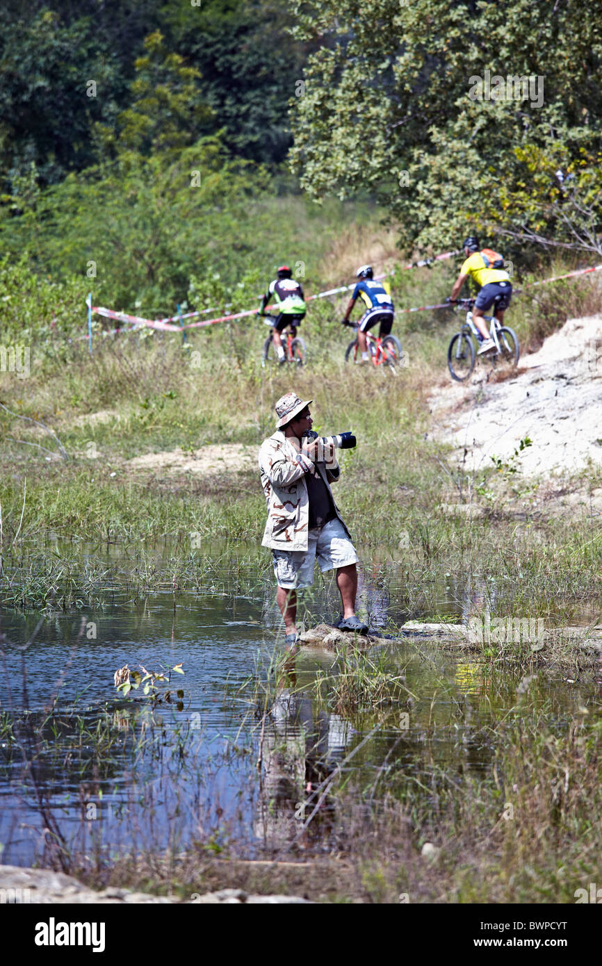 Photographe travaillant à l'extérieur à un cross country location événement. S. E. Asie Thaïlande Banque D'Images