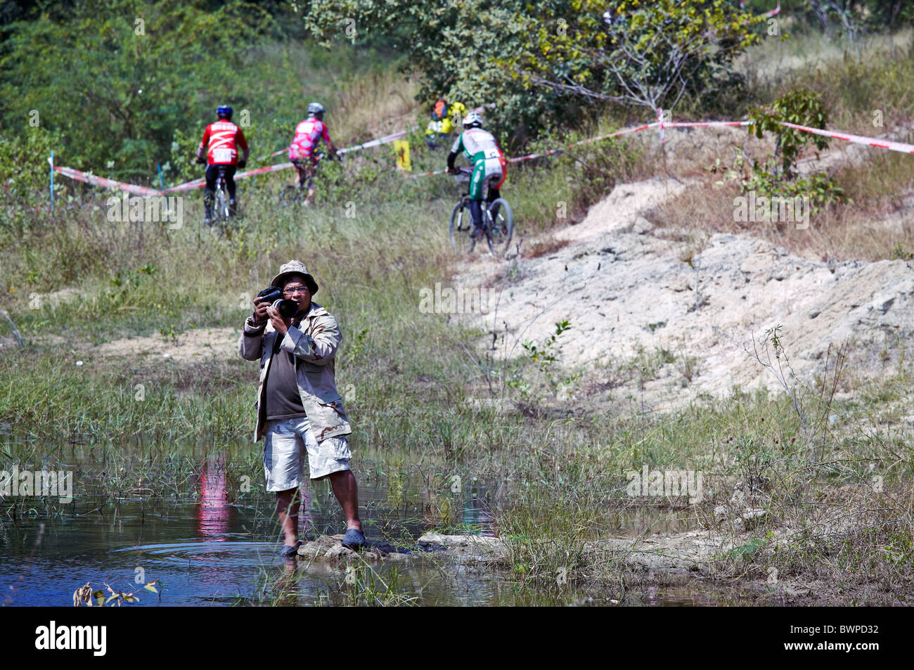 Photographe travaillant à l'extérieur à un cross country location événement. S. E. Asie Thaïlande Banque D'Images