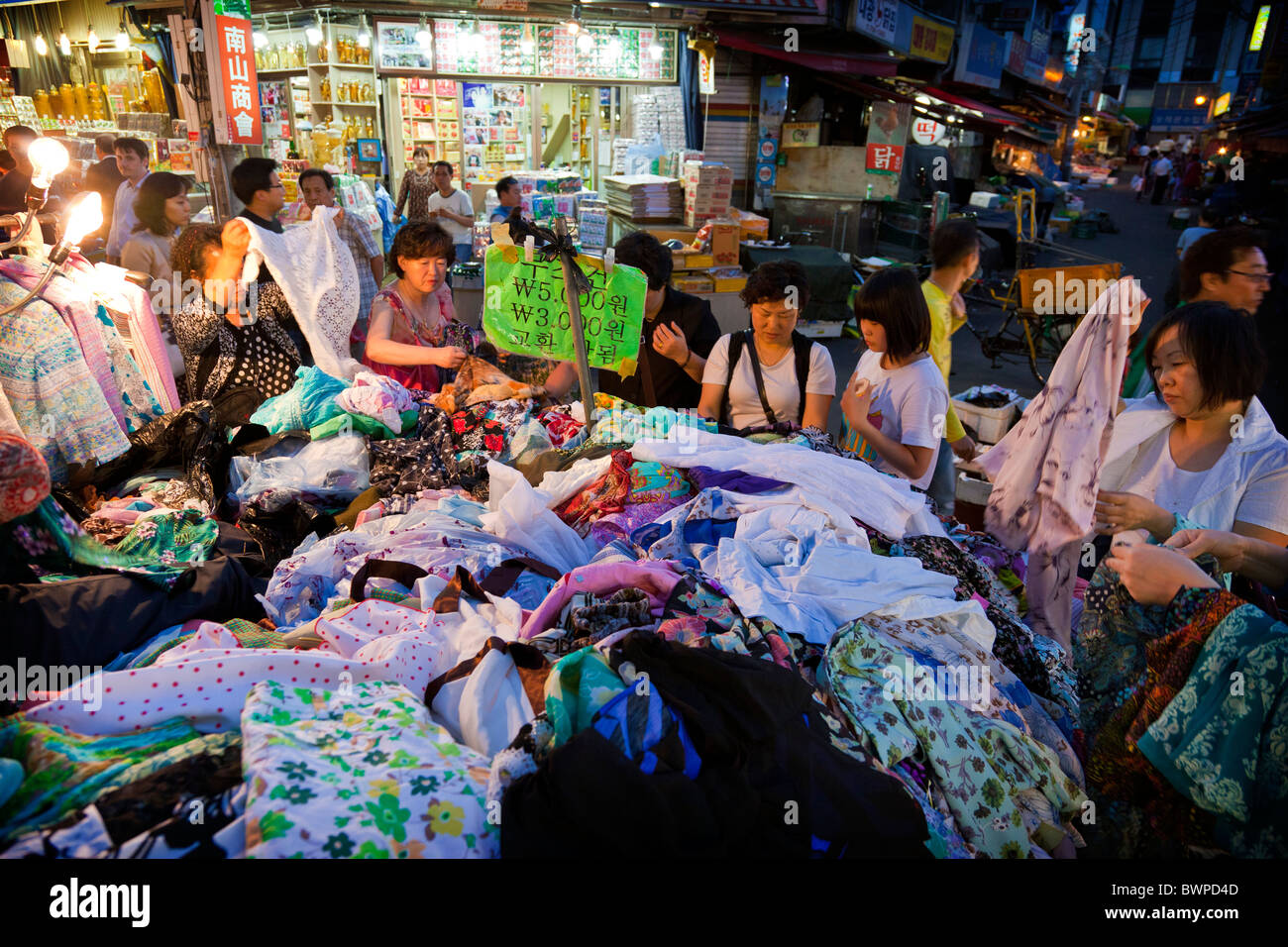 Les femmes coréennes du shopping à bloquer la vente de vêtements dans le marché de Namdaemun à Séoul en Corée du Sud au crépuscule. JMH3855 Banque D'Images