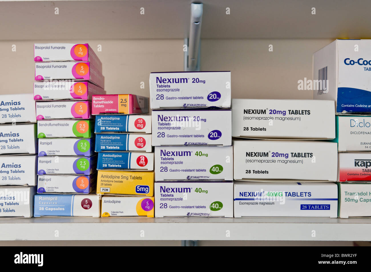 Diverses boîtes de médicaments empilés sur une étagère de pharmacie. Banque D'Images