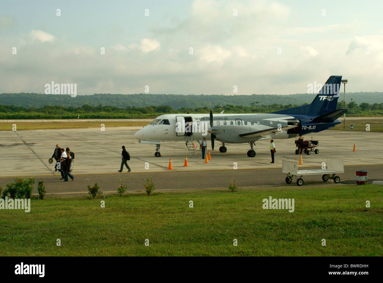 Les passagers de descendre un prop avion à l'aéroport de Santa Elena ou l'aéroport de Mundo Maya, El Petén, Guatemala Banque D'Images