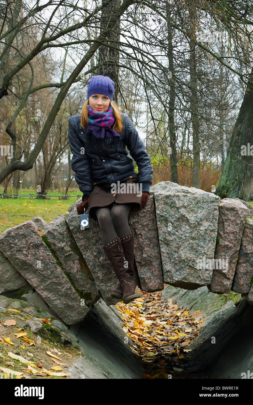 Une fille dans un parc de la ville d'automne se trouve sur les rails en pierre Banque D'Images