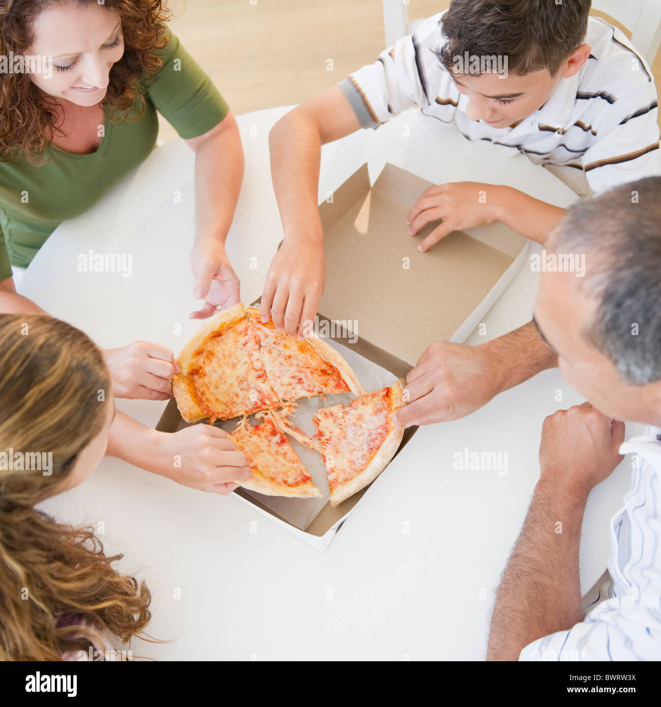 Hispanic family eating pizza together Banque D'Images