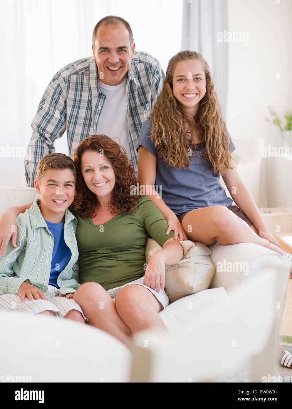 Smiling Hispanic family sitting on sofa together Banque D'Images