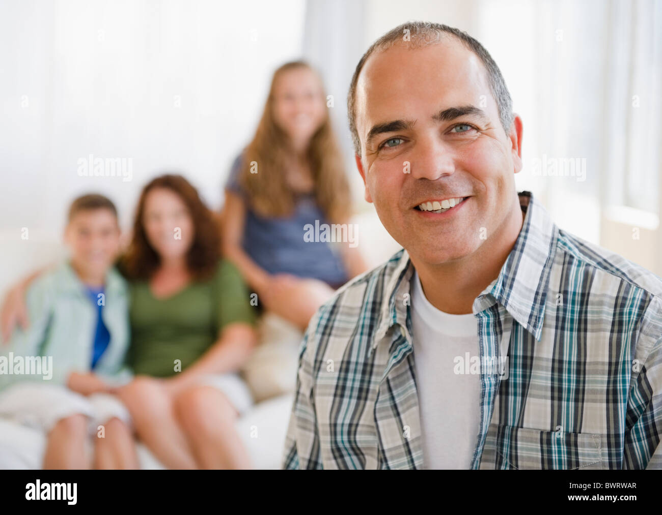 Smiling Hispanic man with family in background Banque D'Images