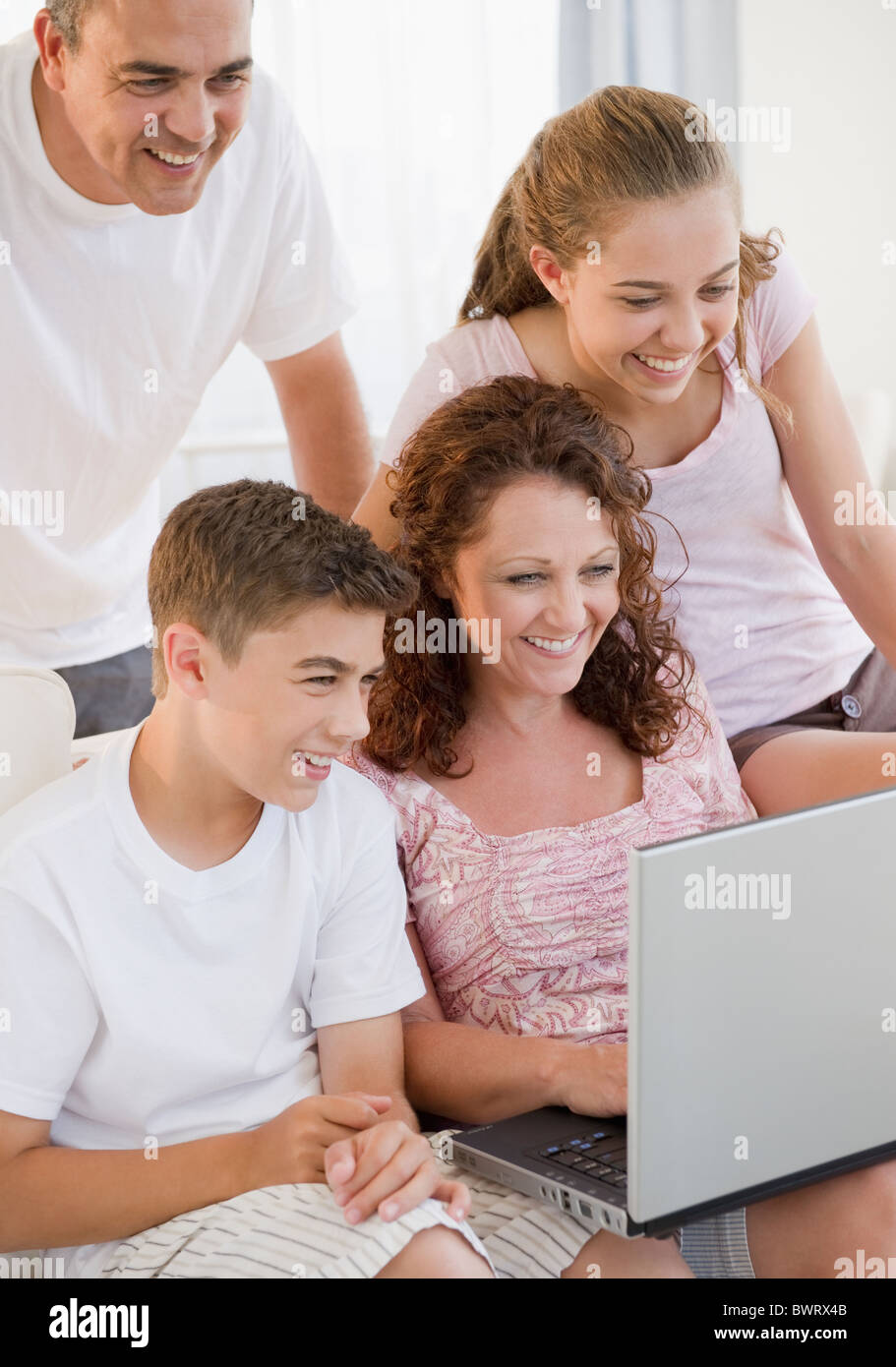 Smiling Hispanic family using laptop together Banque D'Images