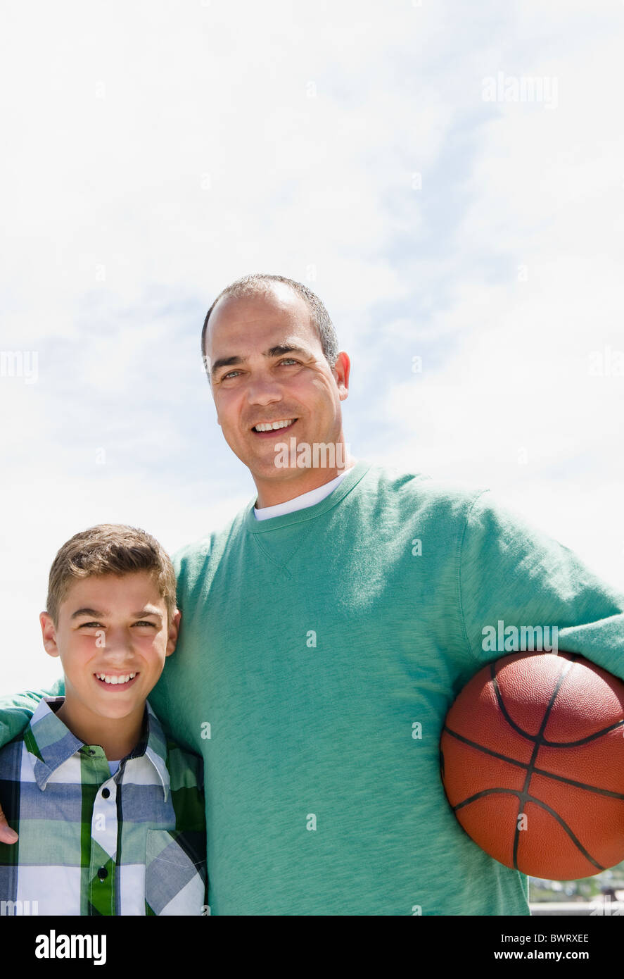 Père et fils hispanique avec le basket-ball Banque D'Images