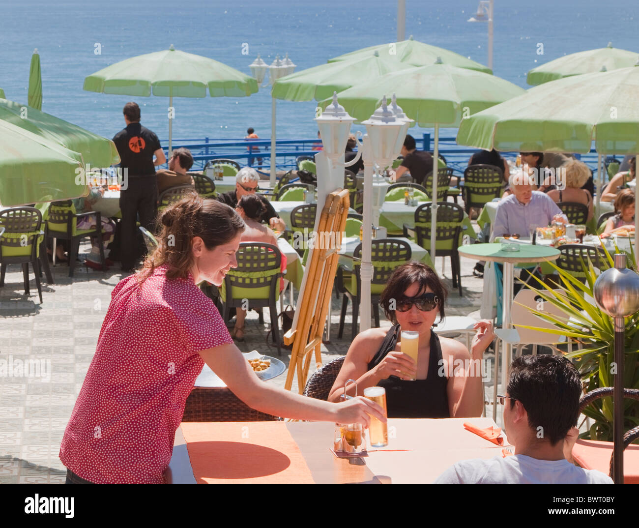 Serveuse servant des boissons au bar extérieur avec vue sur la mer, Nerja, Costa del Sol, Malaga Province, en Espagne. Banque D'Images