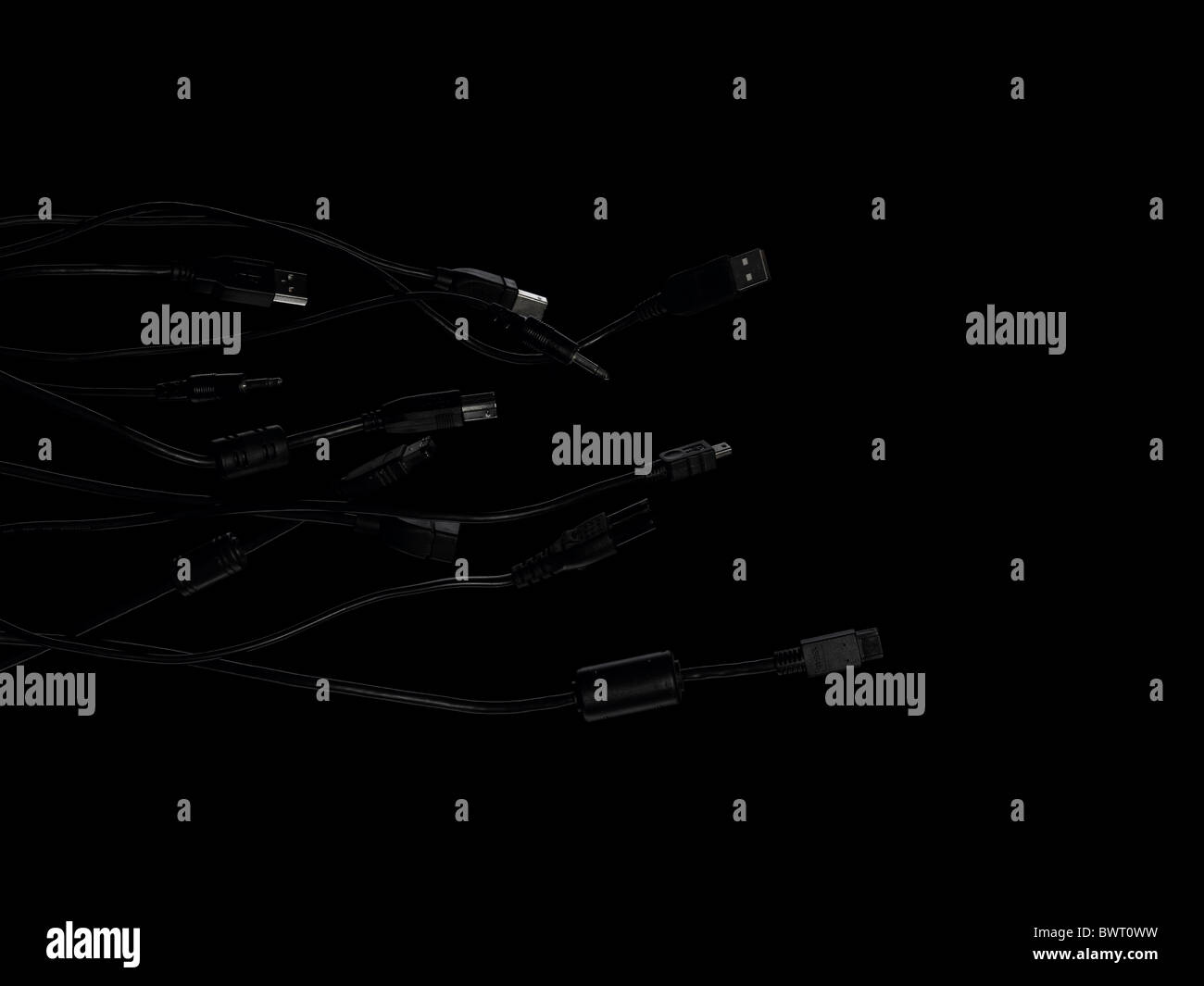 Collection de dark câbles ordinateur tissage entre eux sur un fond noir. Banque D'Images