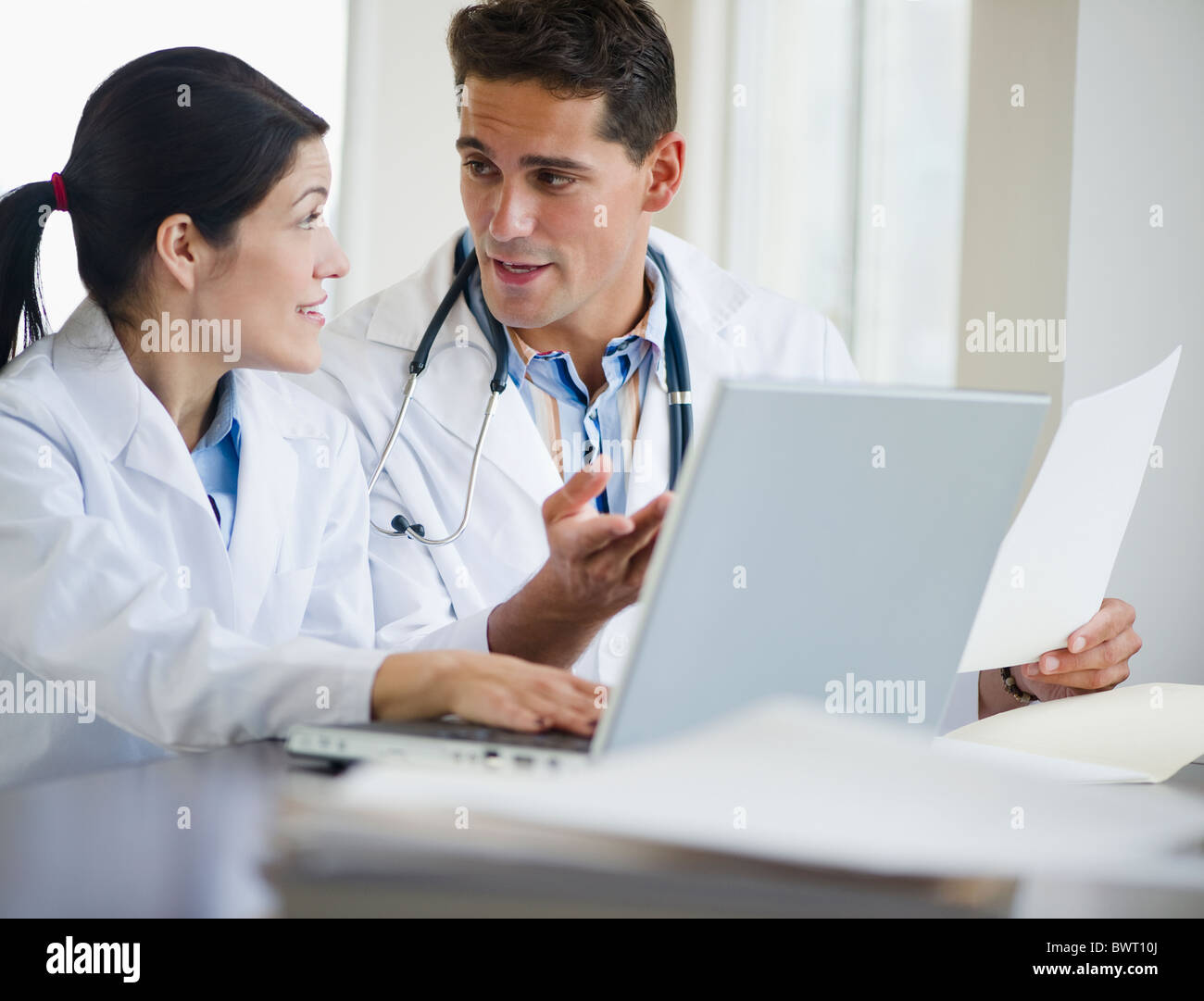 Mixed Race doctors working together on laptop Banque D'Images
