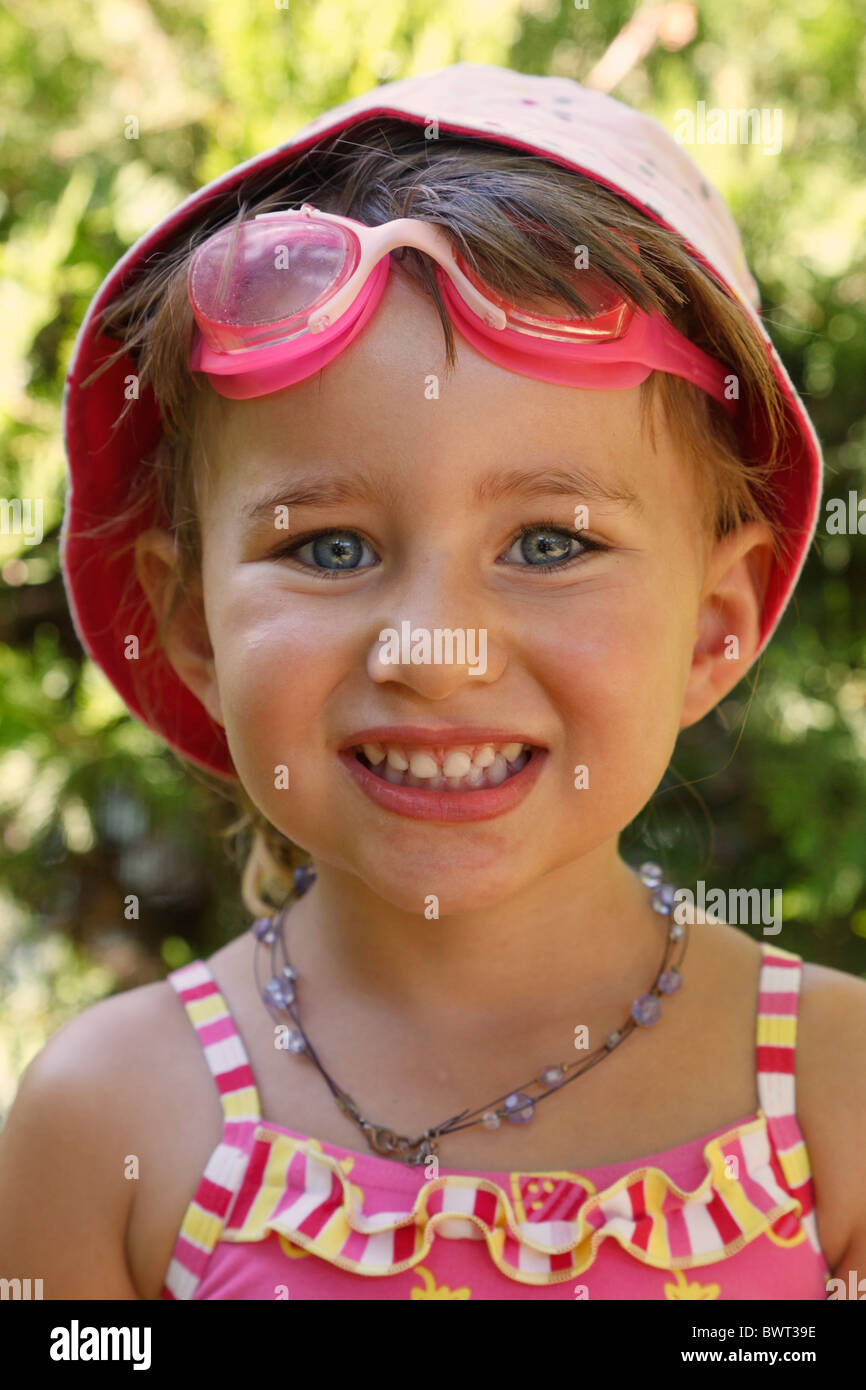 Trois ans girl wearing sun hat maillot et à tout droit à l'appareil photo et de sourire. Banque D'Images