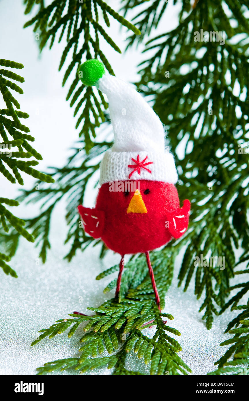 Un mignon christmassy red robin en feutrine, portait un chapeau laineux, dans un paysage de neige à l'hiver. Banque D'Images