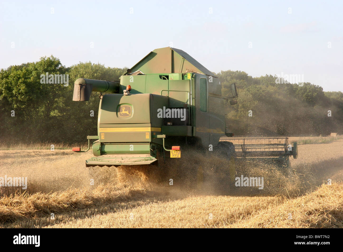 Moissonneuse-batteuse John Deer coupant la récolte dans un champ Dans l'Essex Banque D'Images