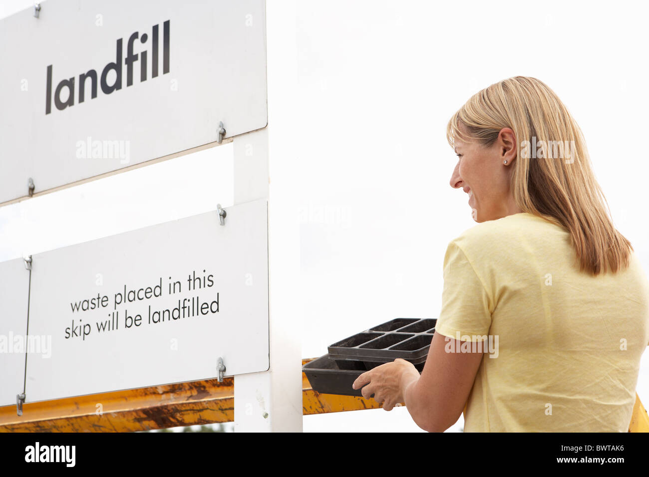 Woman at Recycling Centre Disposing of Cardboard Banque D'Images