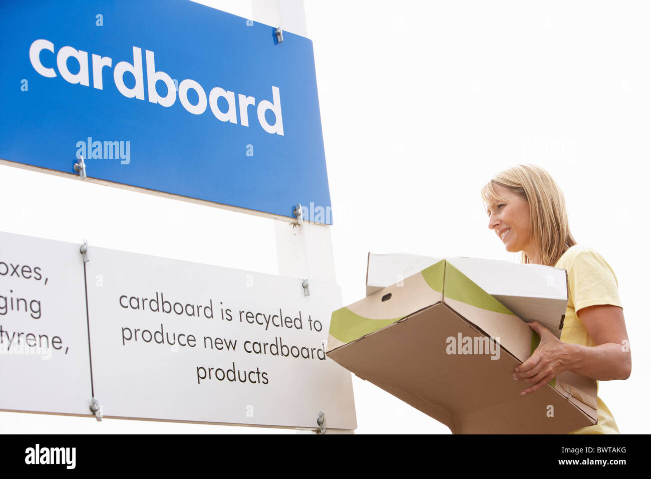 Man at Recycling Centre Disposing of Cardboard Banque D'Images
