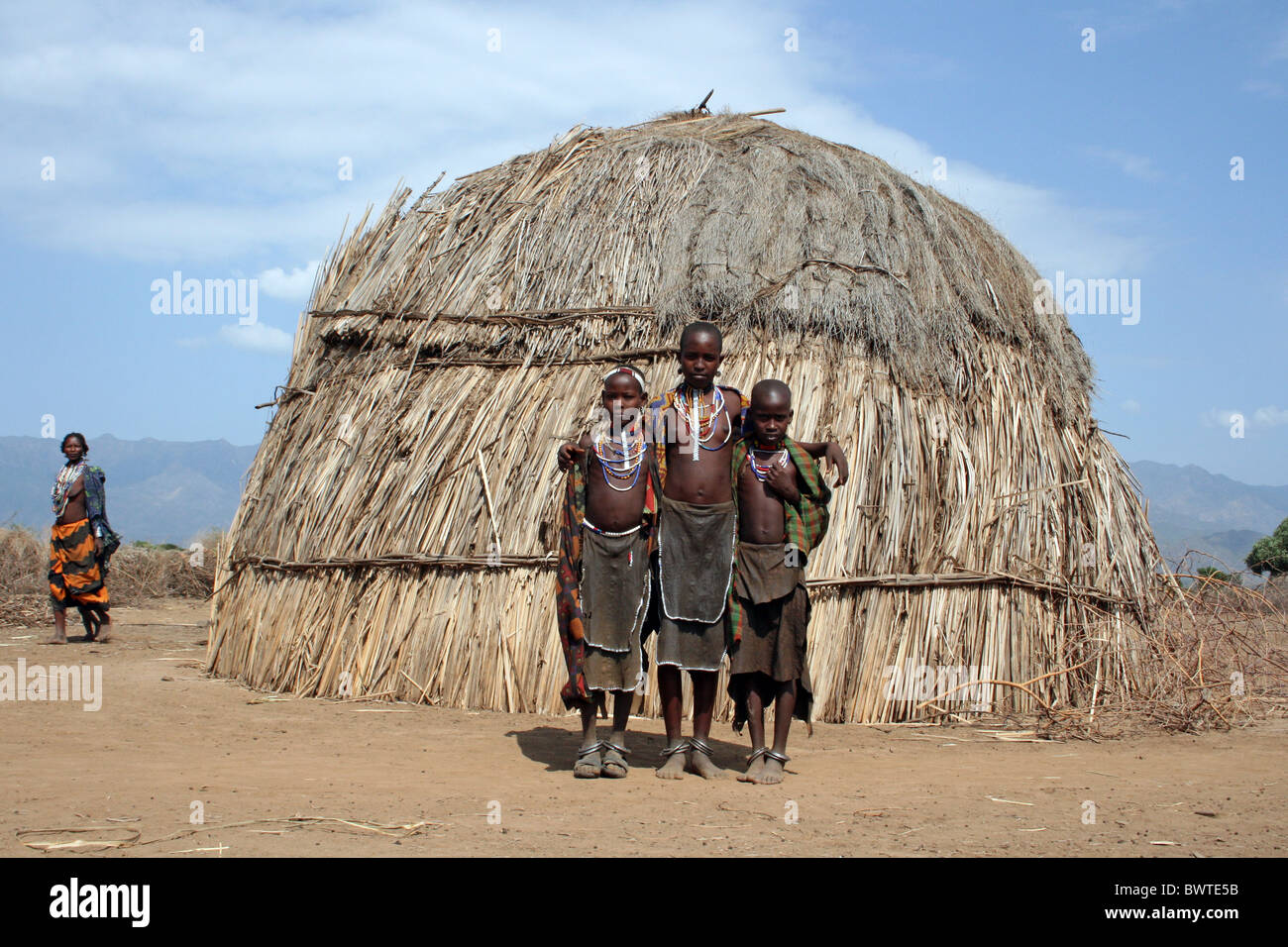 Groupe de tribu arbore les filles debout à côté de Village Hut, vallée de l'Omo, Ethiopie Banque D'Images
