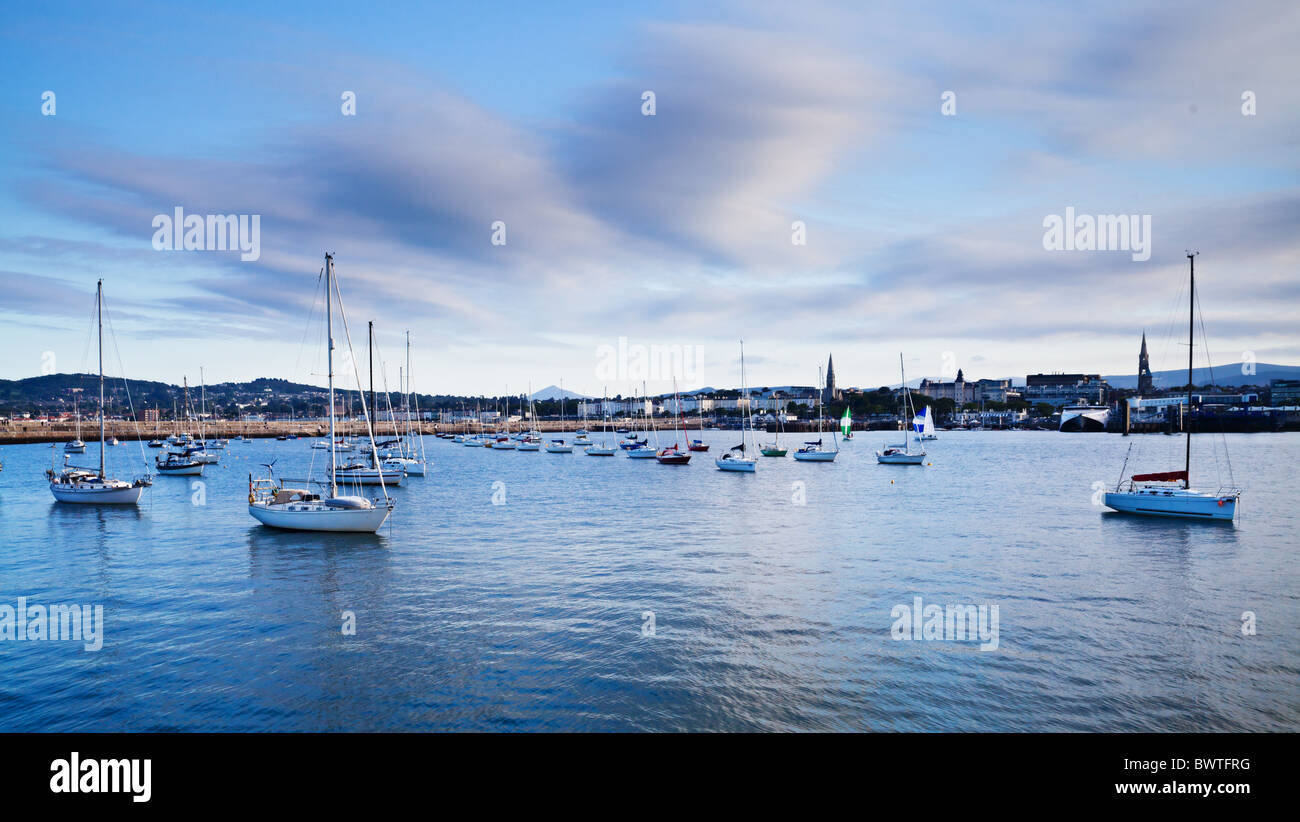 Voiliers ancrés dans un port de la ville au coucher du soleil Banque D'Images