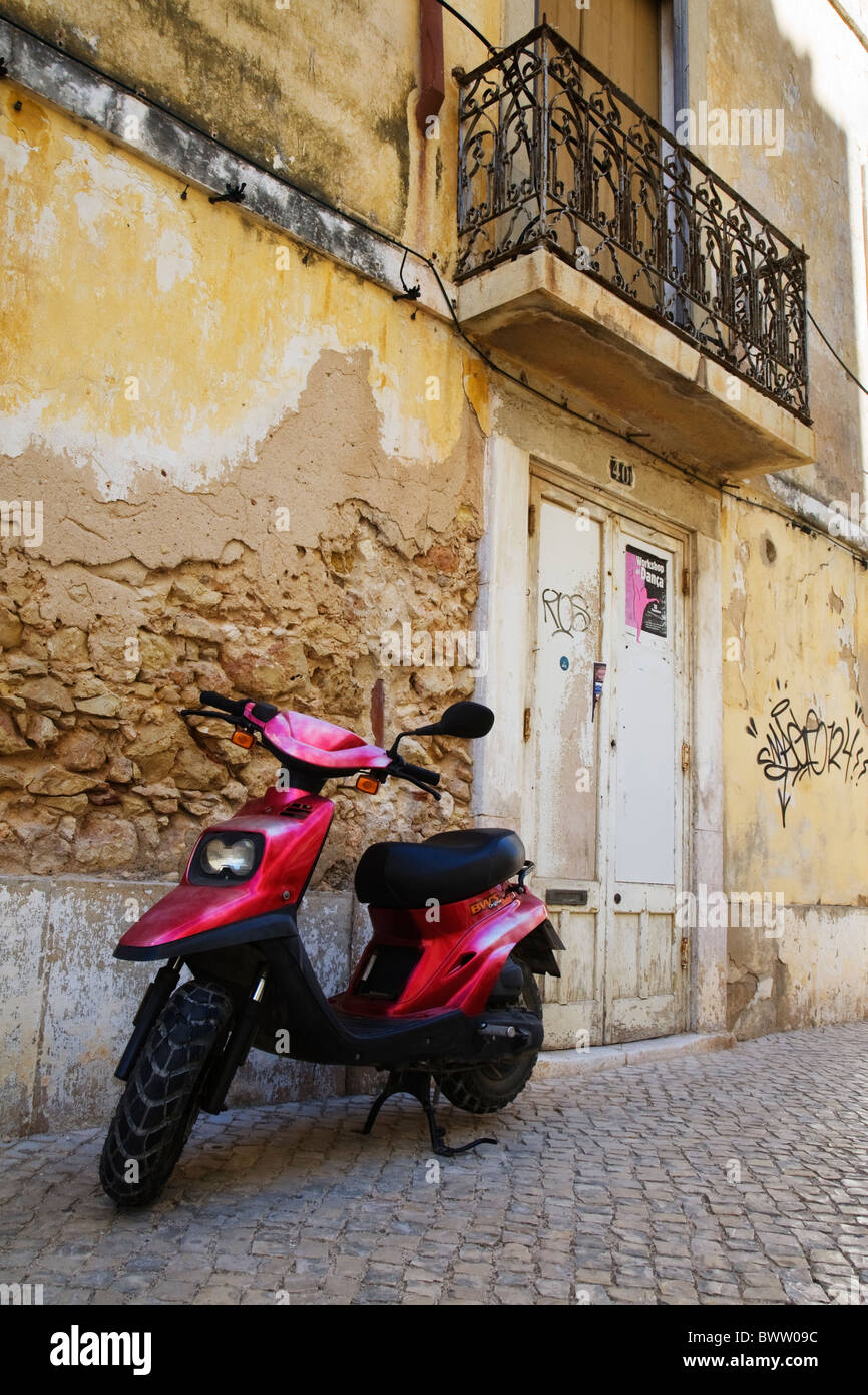 Un scooter se trouve en face d'un vieux bâtiment rustique en 2124. Banque D'Images