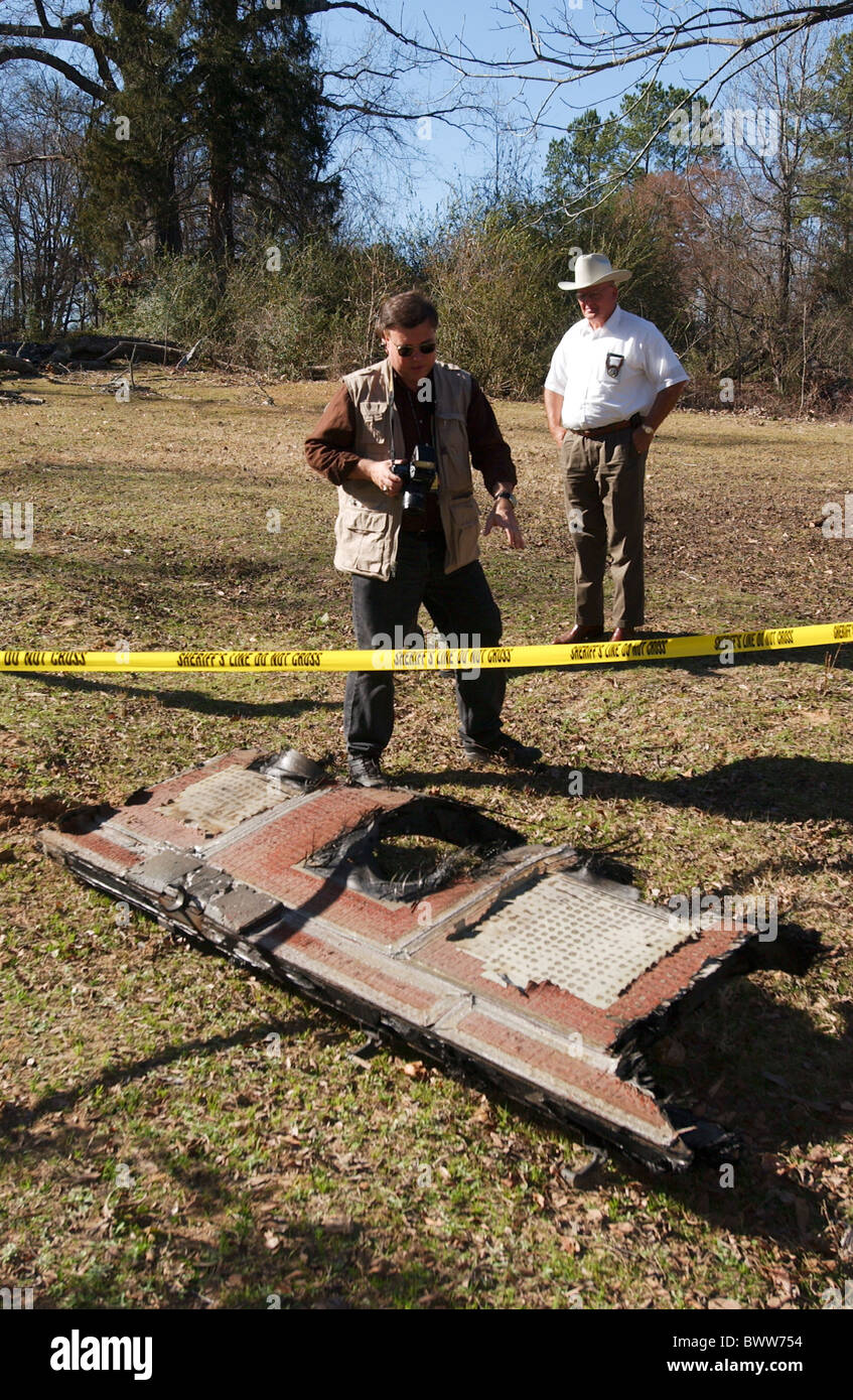 Les agents de la zone sécurisée autour d'un grand morceau de débris de la navette dans un champ en milieu rural dans le nord-est du comté de Cherokee TX. Banque D'Images