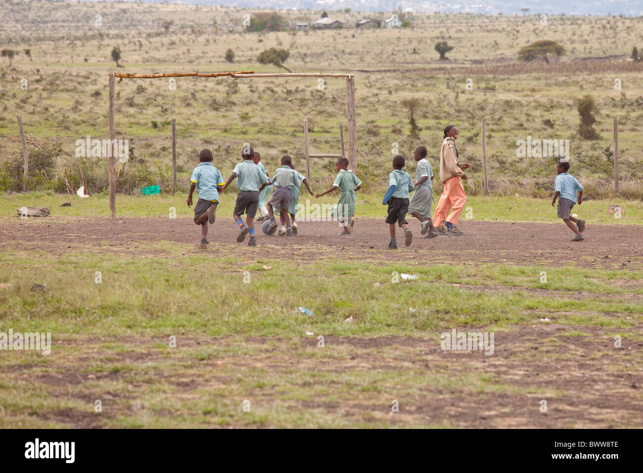 L'enseignant et les enfants jouent au football, Maji Mazuri centre et école, Nairobi, Kenya Banque D'Images