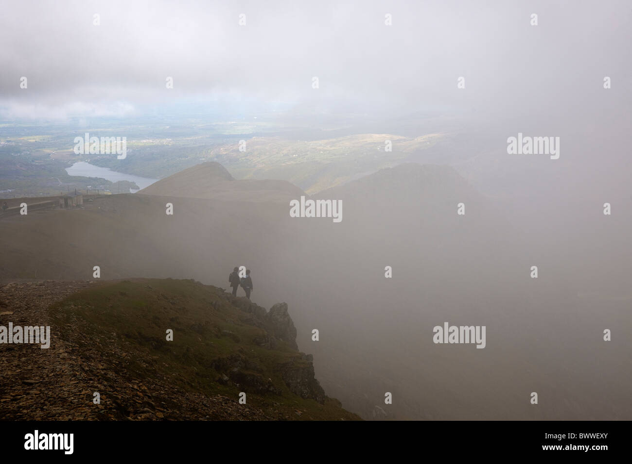 Deux marcheurs sur le chemin d'Idan Snowdon sommet. Donnant sur mcg Glas par le défrichement de nuages. Three Wells Llyn visible. Banque D'Images