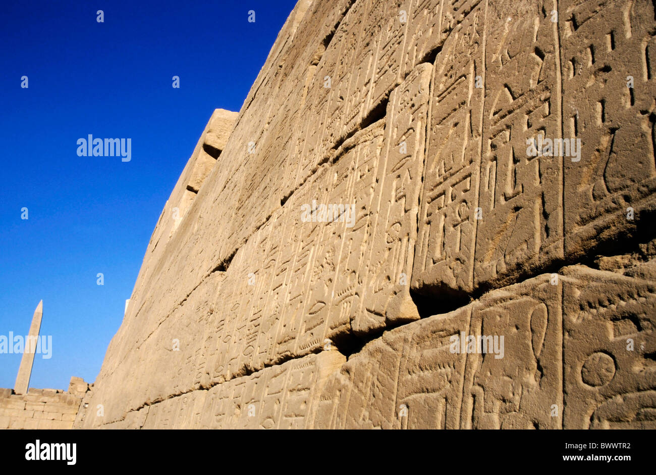Mur plein de hiéroglyphes et d'un obélisque au complexe du temple de Karnak à Louxor, Egypte. Banque D'Images