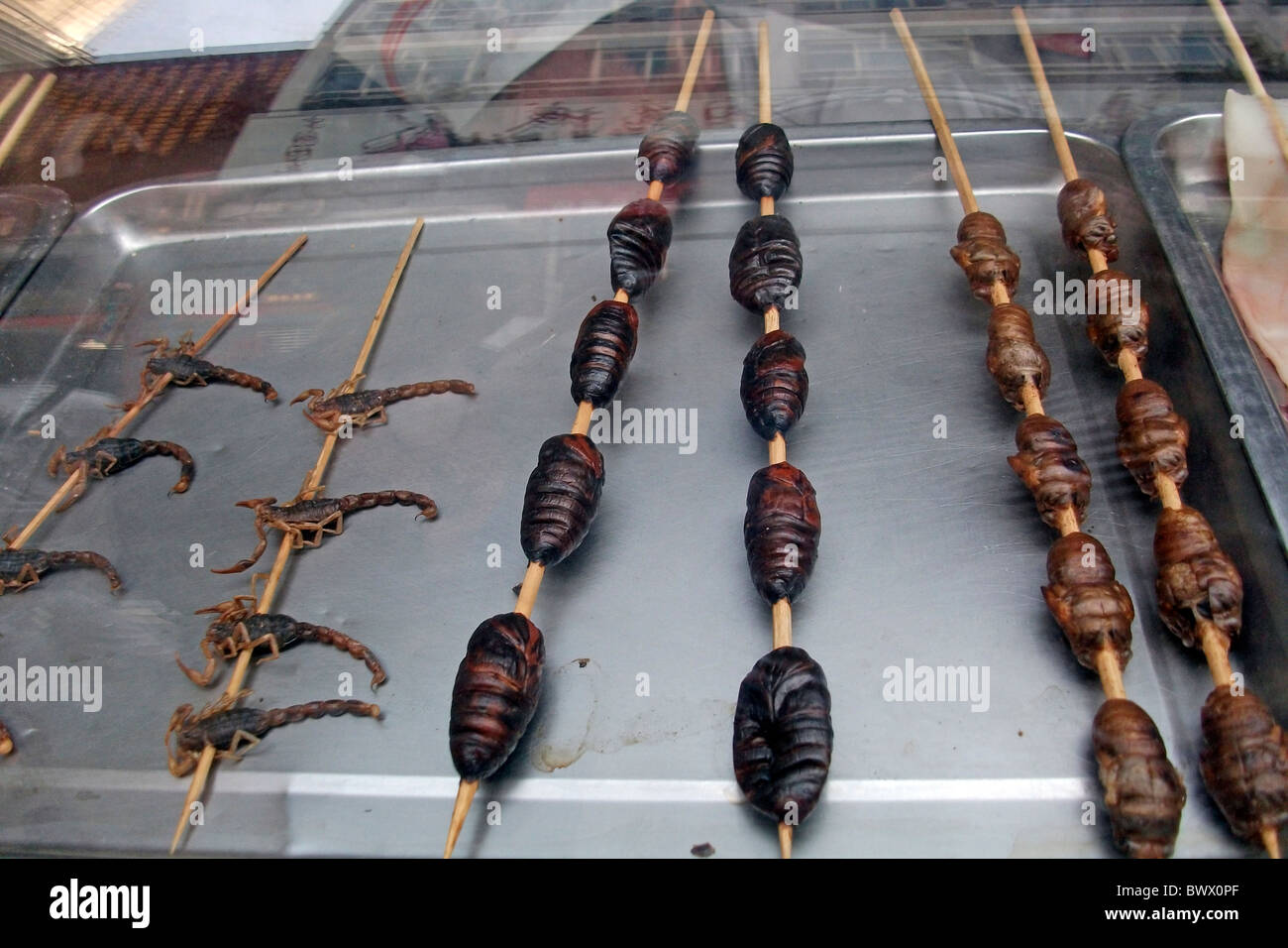 Une sélection de délices sur un marché chinois dont les vers blancs et de scorpion. Des plats à emporter chinois en Chine. Banque D'Images