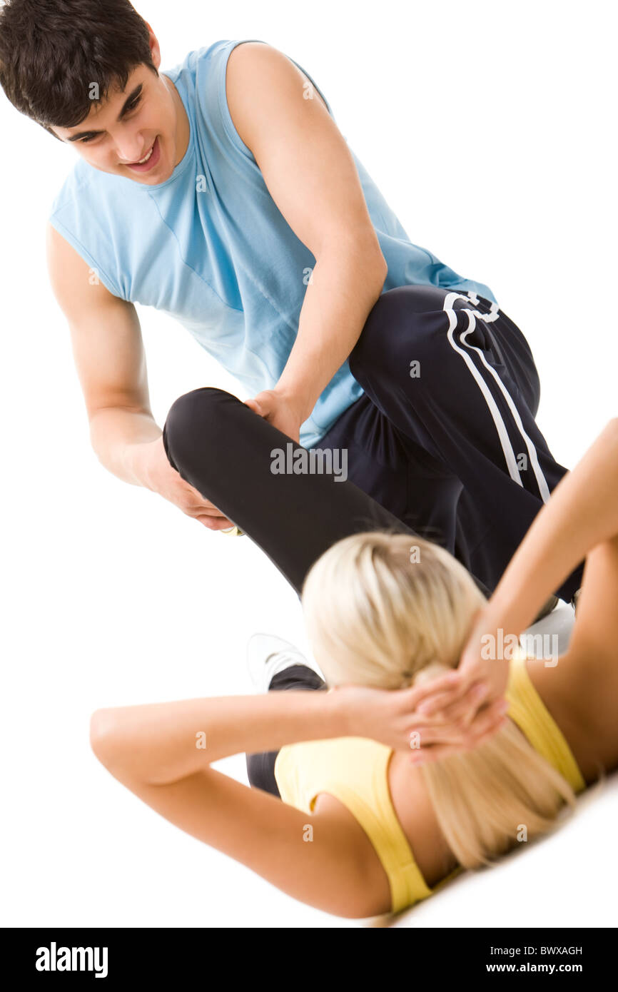 Photo de la sportive faisant de l'exercice physique avec l'aide de l'enseignant Banque D'Images